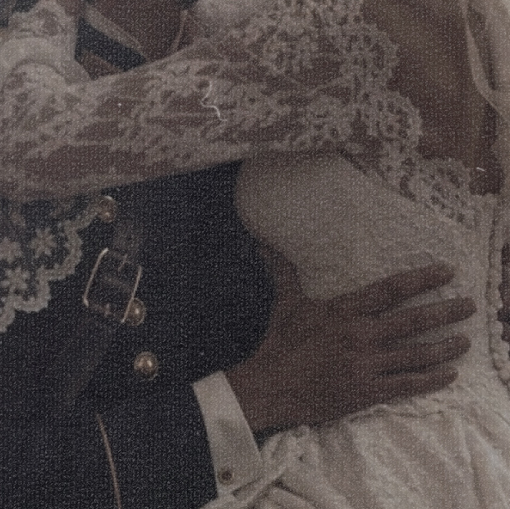Sepia-toned close-up of a couple embracing in vintage lace and uniform