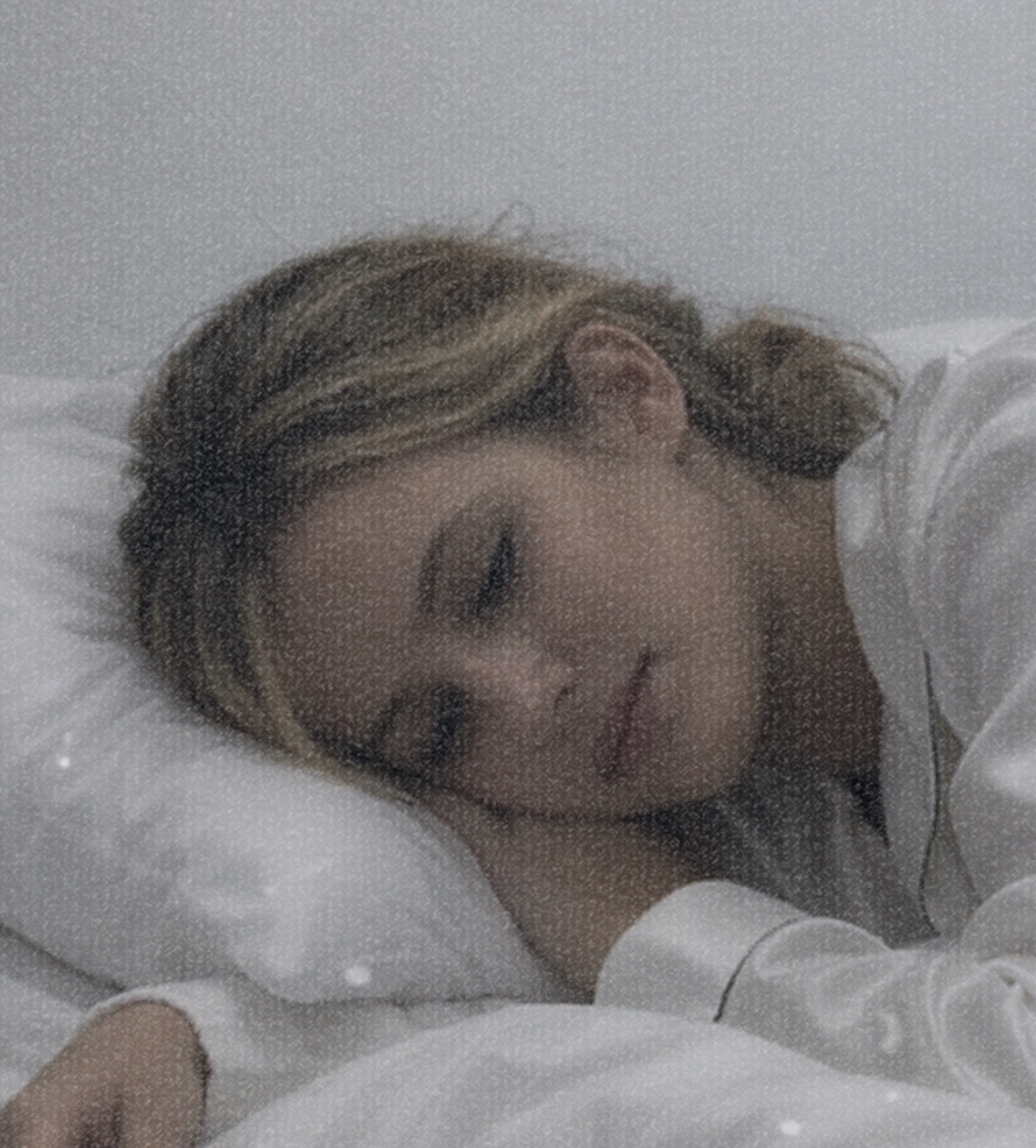 Softly textured portrait of a woman resting on a pillow
