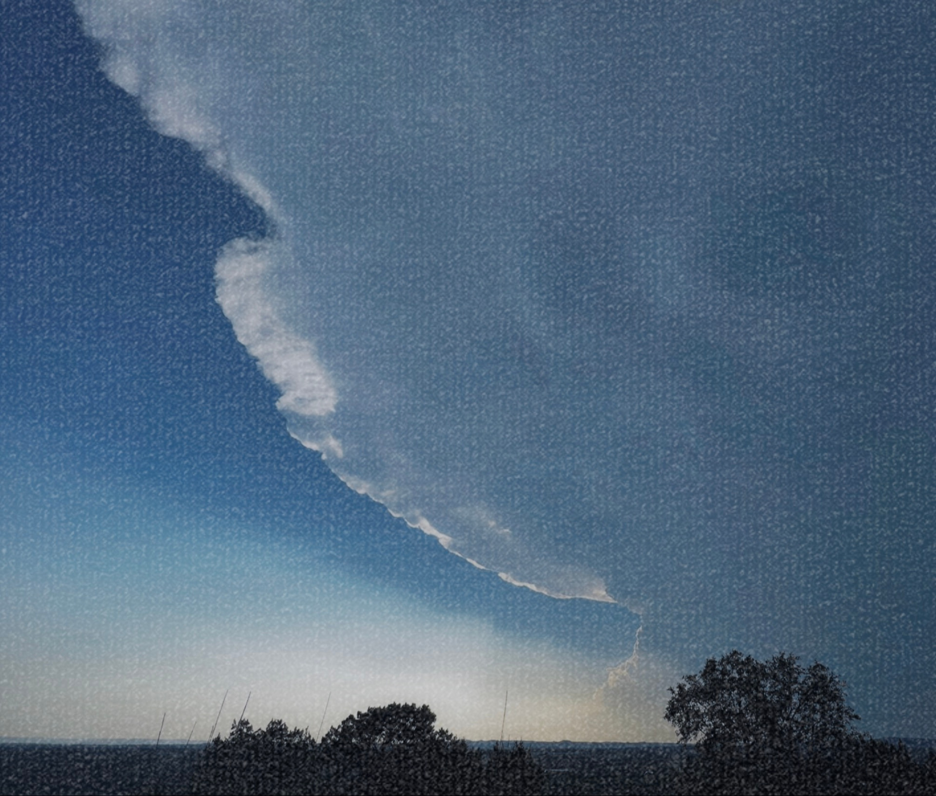 A sweeping storm cloud above trees in the Texas Hill Country