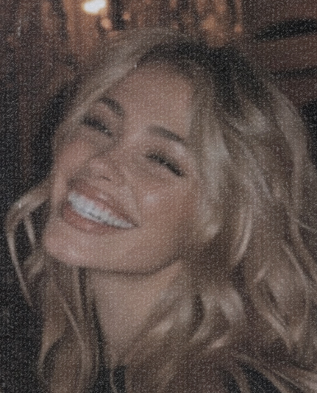 A smiling blonde woman with wavy hair